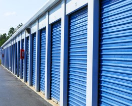 Exterior shot of self storage units with blue doors.