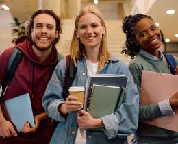 Multiracial group of happy college friends looking at camera.