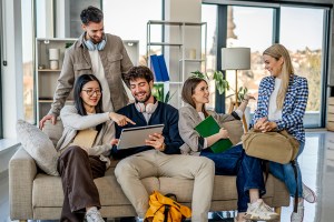 Group of diverse young adults are studying and collaborating together, using a digital tablet for their university project